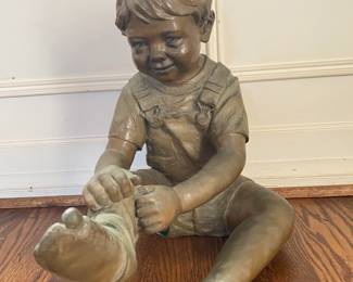 Brass statue of sitting boy.  Broadmoor Galleries