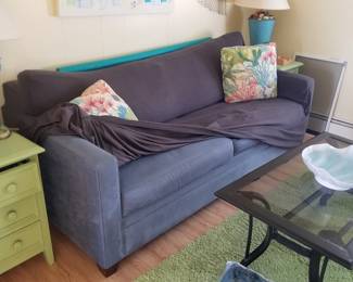 Cozy blue couch (sleeper sofa!) has a protective cover