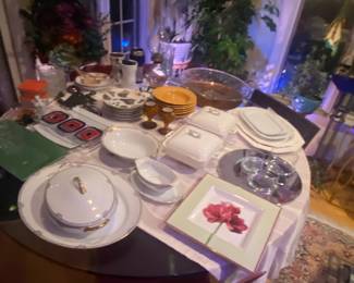 A table of China, serving bowls, and collectible, mid-century, modern glass platter.