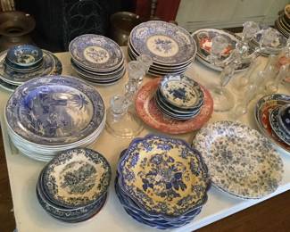 A table full of blue and white decorative plates and other items