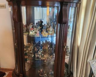 Curved glass cabinet filled with bear and mice figures