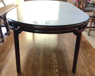 Walnut wood recessed leg dining table shown with 2 leaves in. The top of the table has removeable glass cover to protect the surface. This dining table comes with 8 chairs (2 armchairs and 6 armless chairs). The Dining table with 2 leaves - L: 84.1/4in | W: 45in | H: 30.1/4in. (Without the leaves the table is round and measures 45in in diameter.)