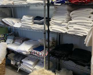 Assorted linens and towels and tablecloths 
$5-10
Metal shelving racks $75-95 (8)
Creme Pouf $65 
Beach Towels $10
