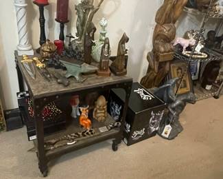 2-tiered coffee table displayed with home decor including candles, tall candleholders, gothic figurines, and ceremonial daggers