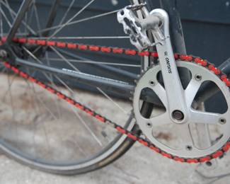 Closer red chain detail of black Bianchi men's road bicycle with Syntace handlebars