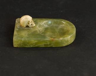 Side view of green Jade ashtray with a skull figurine