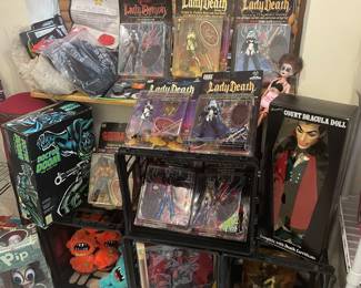 A display of Lady Death figurines and Count Dracula doll, unopened, and other boxed action figures and assorted The Alley memorabilia