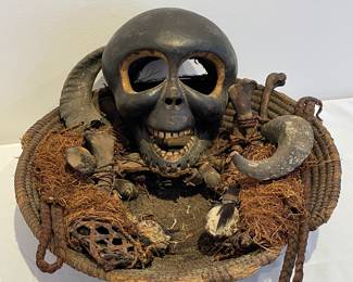 Sculpture: a woven basket with horns and a wooden skull mask