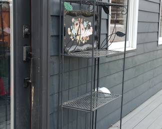 Side view of cast iron floral bakers racks and vintage tole metal tray