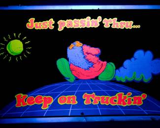Shown under a blacklight, "Just passin' Thru... Keep On Truckin" blacklight poster by Robert Crumb, c. 1970s