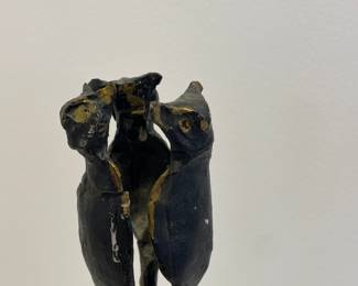 Top detail of pair of bronze candelabras with dogs at the top, vines, and hooves for feet