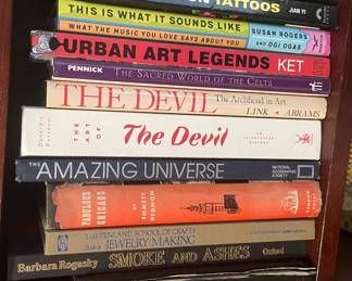 Book collection including: "Tattoo Design Directory", "One Million Tattoos", "This is What it Sounds Like", "Urban Art Legends", "The Sacred World of the Celts", "The Devil: The Archfiend in Art", "The Art of the Devil", "The Amazing Universe", "Fabulous Chicago", "The Penland School of Crafts: Book of Jewelry Making", "Smoke and Ashes", "Dracula's Heir"