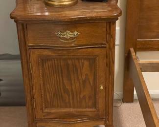 One of two carved cabinets or side tables from a matching antique early 1900s Victorian oak bedroom set