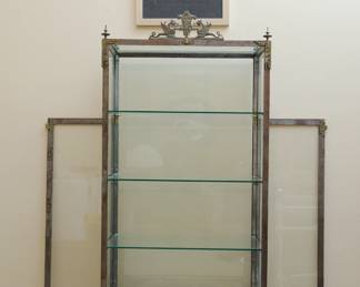 Ornate cast iron and glass vitrine or display case with decorative finials and two sculptural dragons at the top center with two glass doors