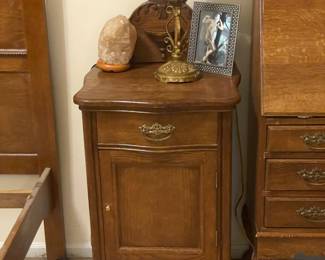 One of two carved cabinets or side tables from a matching antique early 1900s Victorian oak bedroom set