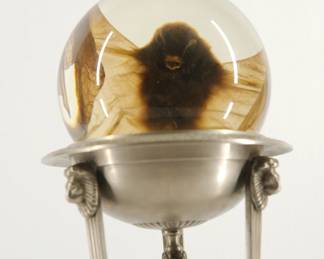A preserved bat from the pair of metal pedestals, each with a crystal ball containing a preserved bat