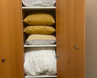 Linen cupboard full throw pillows and duvets