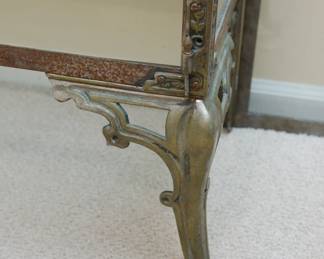 Leg detail of cast iron and glass vitrine or display case with decorative finials and two sculptural dragons at the top center with two glass doors