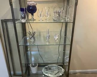 Ornate cast iron and glass vitrine or display case with decorative finials and two sculptural dragons at the top center displayed with barware