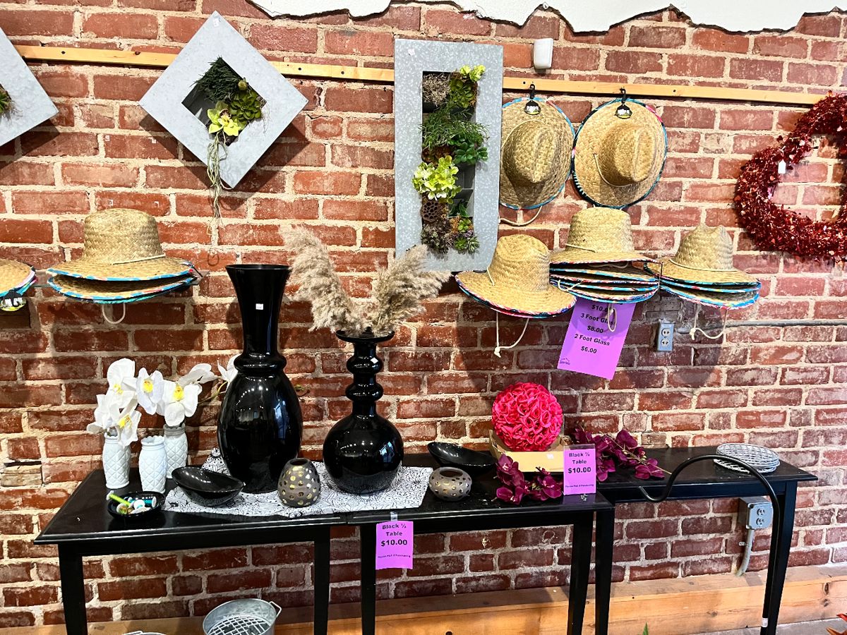 Tin planters with succulents, black 1/2 tables, garden hats