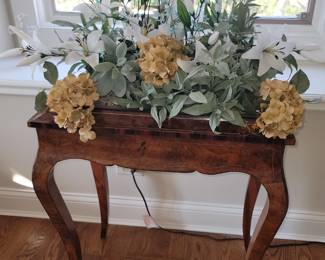 Antique table with open top that has a cover.