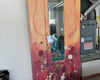 Hand painted armoire has a clothes rack on the inside