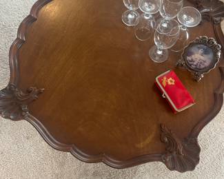 Detail of the walnut round table with shell details on the edge 