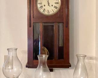 Antique wall clock and hurricane lamps
