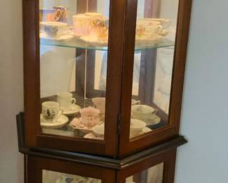 lighted display cabinet filled with tea cups and saucers