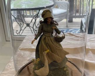 Lady with swan under glass dome.