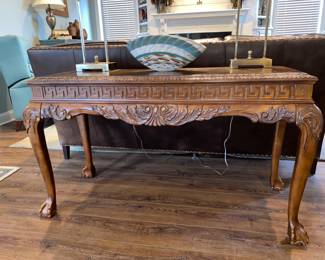 Lovely intricate carved foyer/sofa table with ball and claw feet. Has leather insert in center of top. $250.00