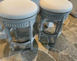 Light gray whitewashed round swivel counter-height stools with metal footrests and upholstered fabric with nailhead detail - set of 2 