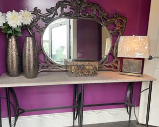 black metal and stone console table, marble and brass low-profile lamp, mirror, storage box, and bronze vases