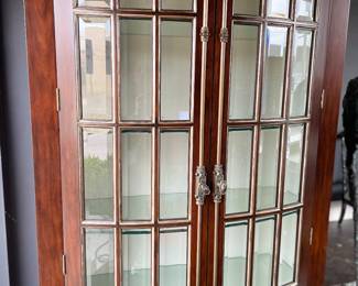 Tall mahogany cabinet with curved front and glass shelves