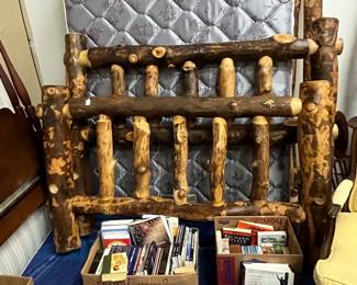 Wooden king bed with headboard footboard and side rails lots of books 