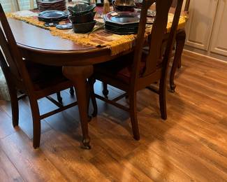 Dinning table with 5 chairs and potters brown dishes and pottery.