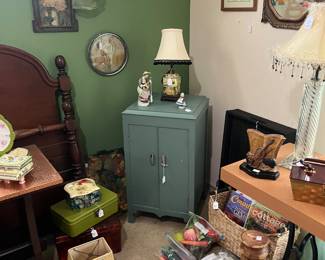 Lots of decor, lamps of all sizes and painted cabinets, vintage postered bed