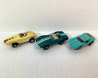 BIHY701 Vintage Aurora TJET TYCO Slot Cars Three vintage Aurora TJET and TYCO slot cars. Includes an Aurora GT in turquoise with a black and white stripe, an Aurora yellow racer (missing exhaust piece on back), and a green 1968 TYCO corvette sports coupe.
