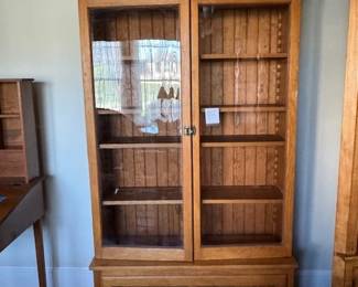Large glass front display cabinet with enbossed "G" emblem near the bottom from local Stowe family.