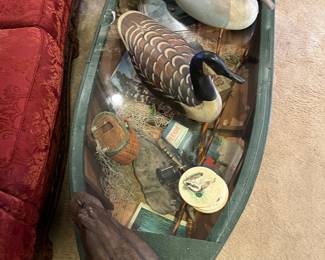 row boat coffee table with hunting decor under glass