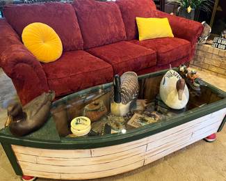 row boat coffee table with hunting decor under glass; duck decoys