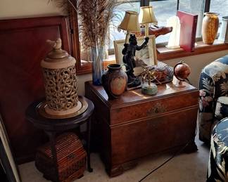 Monkey Bellhop Lamp with Double Light; Wood Trunk with Brass Trim; Round Wood Table with Brass Plate in center with Asian Symbol; Peacock Feathers; and assortment of decorative home furnishings