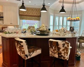 Cowhide upholstered bar height stools anchor the kitchen island 