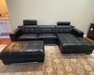 Black leather modern sofa with lounger with matching ottoman on casters