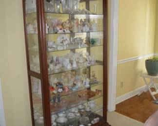 glass and wood curio cabinet full of collectibles