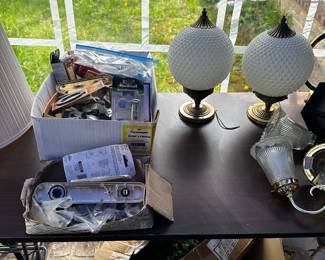 A full banquet table filled with lighting fixtures of all sorts. 