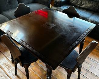 This is a Lovely and Unique table. The top is black marble type material. It has a beautiful pattern around the entire rim and in the center. The wooden table comes complete with 4 chairs! All in GREAT condition! 