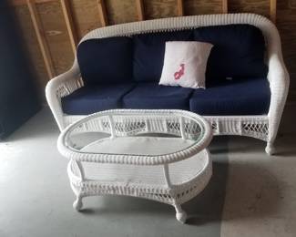 All weather wicker couch with navy cushions; sorry, coffee table is sold