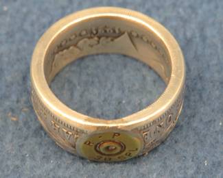Lot 139. Morgan Silver dollar ring with a 38 Special casing head inlaid, approx. size 13