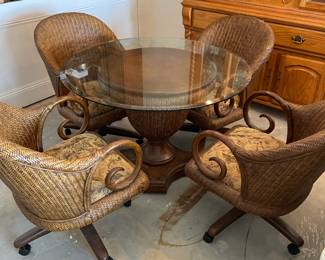 Rattan Round Glass top kitchen with 4 chairs on casters.     Table: 42" diameter, 30" t  Chairs: 23"w 19"d 33"t  4 casters.  